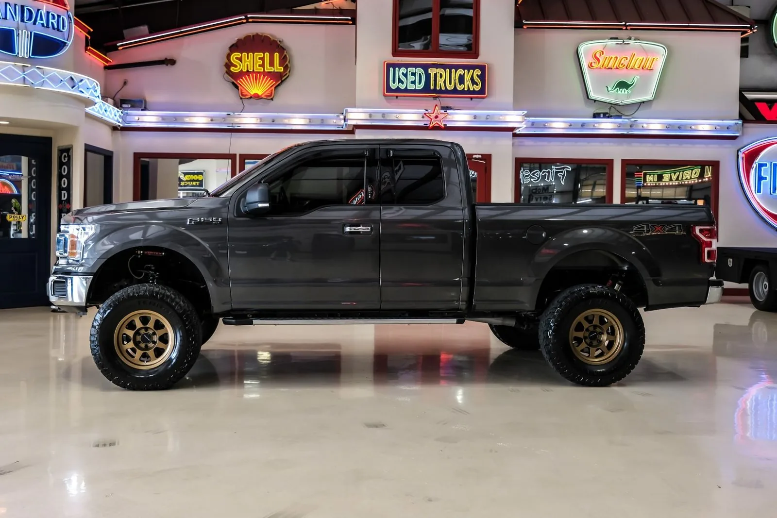 Grey lifted Ford F-150 4x4 extended cab bought by Texas Motorcars